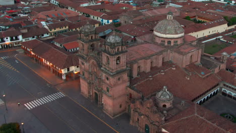 Establishing-aerial-shot-of-Iglesia-de-la-Compania-de-Jesus,-a-historic-landmark-in-Plaza-de-Armas,-Cusco,-Peru