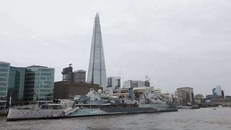 HMS-Belfast-Town-class-Light-Cruiser-Moored-On-River-Thames-With-The-Shard-Skyscraper-In-Background-In-London,-United-Kingdom