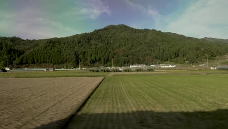 Vista-Del-Campo-Entre-Toyama-Y-Kanazawa,-Japón,-Observada-Desde-La-Ventana-De-Un-Tren-En-Movimiento,-Que-Resume-La-Esencia-De-Los-Viajes-Y-Los-Desplazamientos-Diarios.