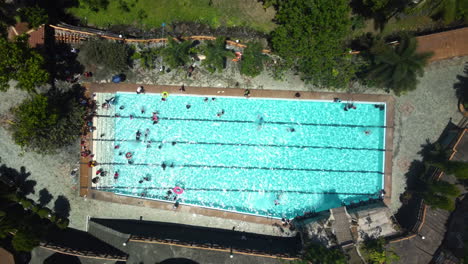 Kids-enjoying-and-swimming-in-a-pool,-in-sunny-Luzon,-Philippines---Aerial-view