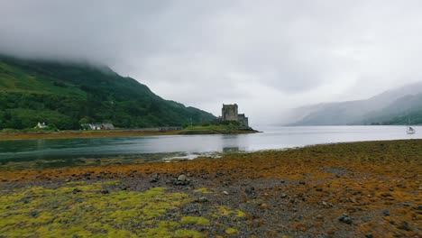 Niedrige-Luftaufnahme-Des-Berühmten-Eilean-Donan-Castle-An-Einem-Nassen-Und-Bewölkten-Herbsttag-Im-Schottischen-Hochland,-Schottland,-Großbritannien