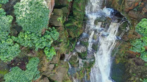 Aerial-drone-footage-of-a-tall-rocky-waterfall-in-the-Yorkshire-Dales,-Pennies