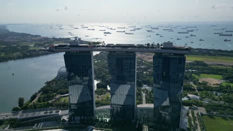 Aerial-view-of-Marina-Bay-Sands-with-ships-in-background,-descend-tracking-shot