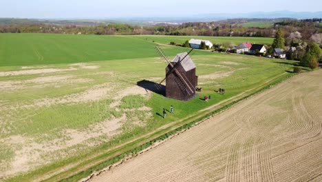 Nové-Dvory,-Bilovec,-Nový-Jičín-District,-Czech-Republic---People-Appreciating-the-Historic-Windmill-Set-Against-a-Rural-Backdrop---Aerial-Drone-Shot