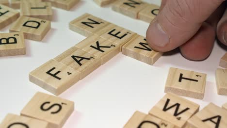 Scrabble-letter-tiles-form-crossword-FAKE-and-NEWS-on-white-table