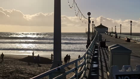 Waves-rolling-over-the-beach-and-people-walking-on-the-sand