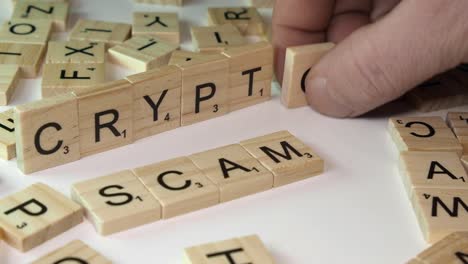 Closeup-on-table-top:-Scrabble-tile-letters-form-words-CRYPTO-and-SCAM