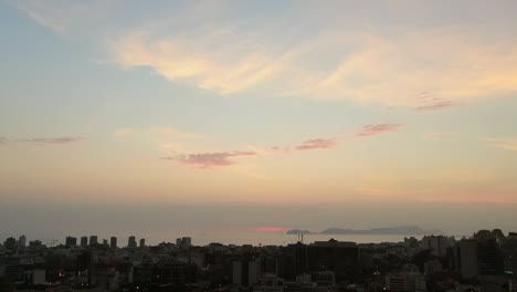 Flying-Over-The-Miraflores-District-Overlooking-The-Sea-At-Sunset-In-Lima,-Peru---aerial-pullback-shot