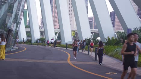 Estilo-De-Vida-Saludable-Singapurense,-Gente-Andando-En-Bicicleta,-Trotando-Y-Paseando-Por-La-Bahía-Marina