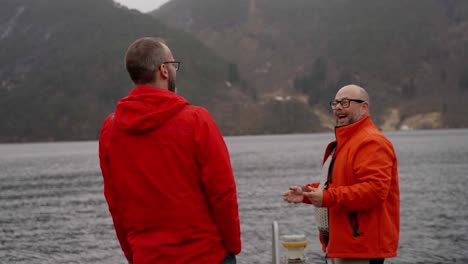 Tourist-guide-explain-and-laugh-telling-stories,-slow-motion-with-fjord-background