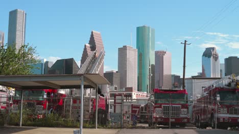 Tomas-De-Un-Patio-Lleno-De-Camiones-De-Bomberos-Discapacitados-Con-El-Centro-De-Houston-Al-Fondo