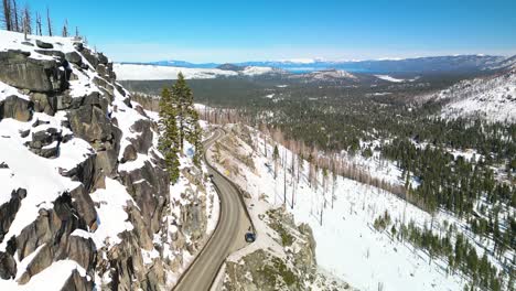 Aerial-view-of-mountainous-highway-outside-of-Lake-Tahoe,-California-in-winter