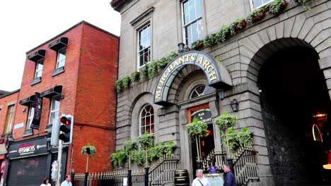 Entrance-to-Mercants-Arch-pub-with-people-walking-on-the-street,-Dublin