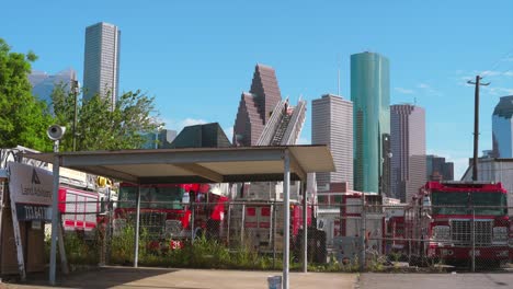 Tomas-De-Un-Patio-Lleno-De-Camiones-De-Bomberos-Discapacitados-Con-El-Centro-De-Houston-Al-Fondo