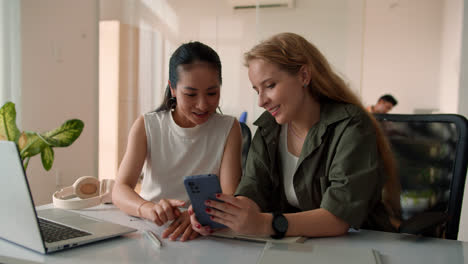 Two-teammates-using-smartphone