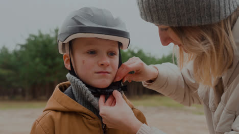 Mutter-Setzt-Sohn-Fahrradhelm-Auf