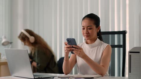 Mujer-Usando-Un-Teléfono-Inteligente-En-La-Oficina