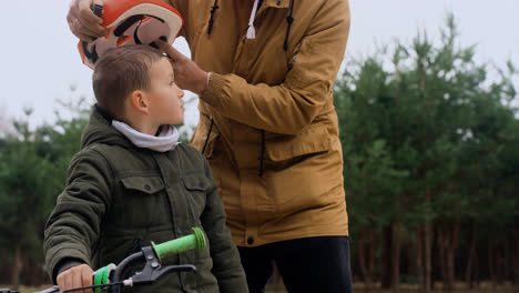 Dad-putting-bike-helmet-on-son