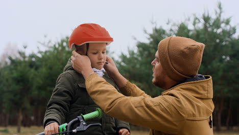 Vater-Setzt-Sohn-Fahrradhelm-Auf