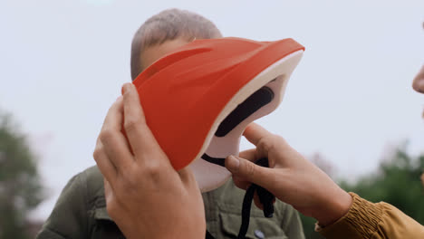 Dad-putting-bike-helmet-on-son