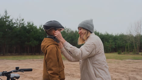 Mom-putting-bike-helmet-on-son