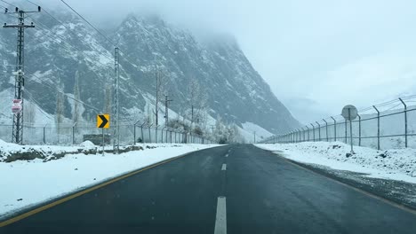 Car-driving-on-a-road-in-Skardu-in-landscape-covered-with-snow-and-high-mountains