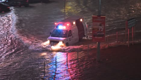 El-16-De-Abril-De-2024,-Una-Ambulancia-Navegó-Bajo-La-Lluvia-En-Una-Carretera-Inundada-En-Sharjah,-Emiratos-Árabes-Unidos,-Después-De-Que-Lluvias-Sin-Precedentes-Azotaran-El-País.