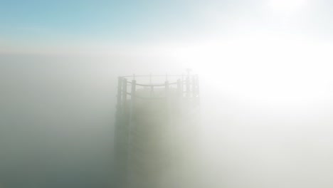 Luftaufnahmen-Eines-Wolkenkratzers,-Der-In-Dichte-Morgenwolken-Gehüllt-Ist