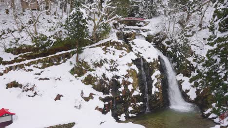 Paisaje-Nevado-De-Ginzan-Onsen,-Cascada-Y-Puente-En-Invierno