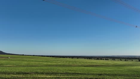 Drone-flying-under-powerlines-near-sunset