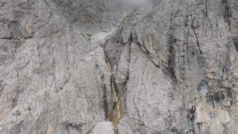 Cinematic-descending-aerial-view-of-the-Murfreit-waterfall-near-Passo-Gardena