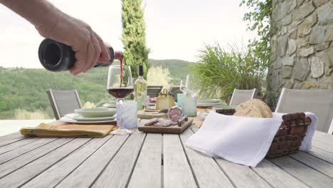 Kellner-Männliche-Hand-Gießt-Roten-Italienischen-Wein-In-Ein-Glas-Auf-Einem-Tisch-Mit-Brot-Und-Vorspeise-Essen-Gourmet
