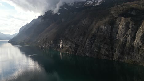 Toma-Aérea-Del-Acantilado-De-La-Colina-Con-Un-Paisaje-Celeste-Al-Fondo-En-Walensee,-Suiza