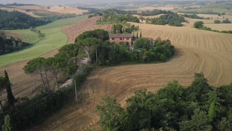 Aerial-view-of-Tuscany-landscape-with-road-and-cypresses-of-farmland-hill-country-at-sunset