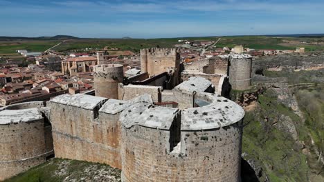 Spinning-aerial-view-of-Berlanga-de-Duero-castle,-Soria,-Spain,-with-the-medieval-village-at-the-back