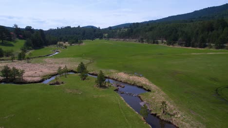 Aerial-View-of-Creek-Between-Woods-and-Pastures-in-Landscape-of-Zlatibor-Mountain,-Serbia