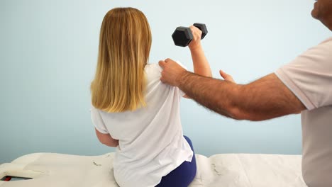 Blonde-woman-doing-dumbbell-exercises-during-a-physiotherapy-session