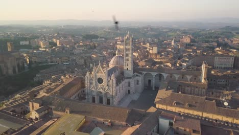 Luftaufnahme-Bei-Sonnenuntergang-Der-Mittelalterlichen-Stadt-Siena-In-Der-Toskana,-Italien,-Drohne-Dreht-Sich-Um-Die-Hauptkathedrale-Duomo-Im-Gotischen-Stil,-Reiseziel