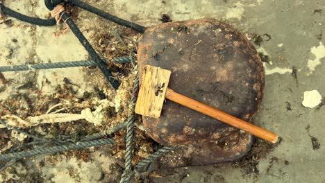 Wooden-tool-rest-outdoors-beside-the-anchor,-embodying-the-essence-of-a-traditional-fishing-village-lifestyle