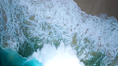 Motion-of-ocean-water-coming-ashore,-picturesque-aerial-birdseye-view