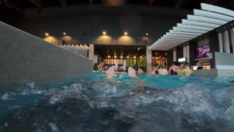 POV-Male-Feet-In-Swimming-Pool---Tourists-Enjoying-A-Resort's-Swimming-Pool-In-Jurmala,-Latvia