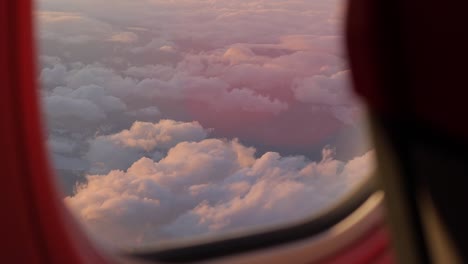 La-Ventana-Del-Avión-Ofrece-Una-Vista-Panorámica-De-Las-Nubes-Iluminadas-Por-El-Sol,-Que-Proyectan-Un-Brillo-Sereno-Y-Simbolizan-La-Esencia-De-Los-Viajes-Y-Las-Vacaciones.