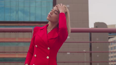 A-rooftop-in-Port-of-Spain,-Trinidad,-hosts-a-young-girl-of-Hispanic-origin,-adorned-in-a-red-dress,-with-tall-buildings-as-the-backdrop