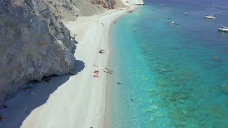 Aerial:-Flying-over-the-Lalaria-beach-in-Skiathos-island,-Sporades,-Greece-with-turquoise-and-emerald-crystal-clear-water