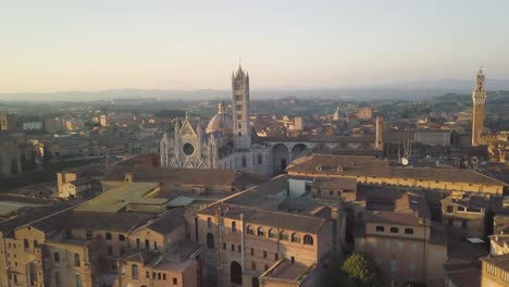 Vista-Aérea-Del-Paisaje-Urbano-De-La-Ciudad-De-Siena-En-Toscana-Italia-Con-La-Cúpula-De-La-Catedral-Al-Atardecer,-Característico-Pueblo-Italiano-De-Estilo-Gótico-Medieval