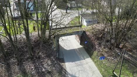 Flying-a-drone-over-an-old,-disused-railway-viaduct-under-which-there-is-a-road-for-cars