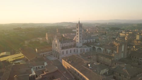 Siena,-Mittelalterliche-Alte-Gotische-Stadt-In-Der-Toskana,-Italien,-Luftaufnahme-Bei-Sonnenuntergang,-Drohne-Dreht-Sich-Um-Das-Hauptsehenswürdigkeitsdenkmal-Des-Doms