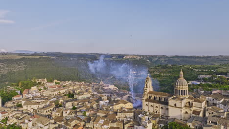 Ragusa-Italy-Aerial-v9-drone-fly-around-Ibla-historic-district-capturing-charming-townscape-featuring-landmark-cathedral-of-San-Giorgio-with-fireworks-display---Shot-with-Mavic-3-Cine---June-2023