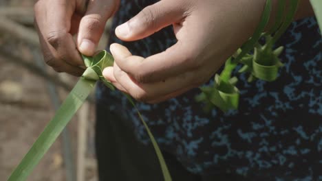 Nahaufnahme-Von-Männlichen-Händen-In-Tansania,-Die-Handgemachte,-Ineinander-Verschlungene-Sterne-Aus-Zitronengrasblättern-Herstellen,-Um-Sie-Zu-Verkaufen