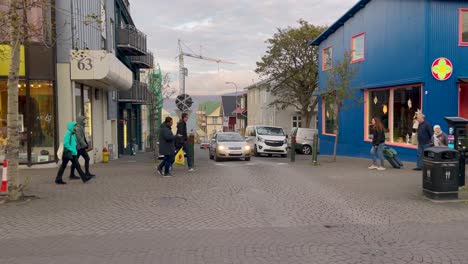 Cars-Driving-on-Street-In-Reykjavik-With-Pedestrians-In-Iceland,-wide-shot